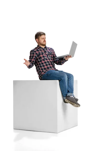 Full-length portrait of man with expression of misunderstanding having business video call on laptop isolated over white background — Foto Stock
