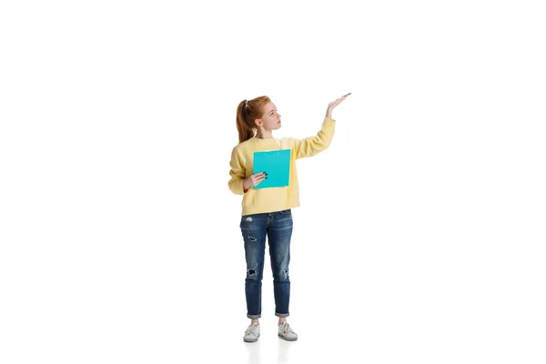 Полнометражный портрет молодой девушки, указывающей вверх, на белом фоне — стоковое фото
