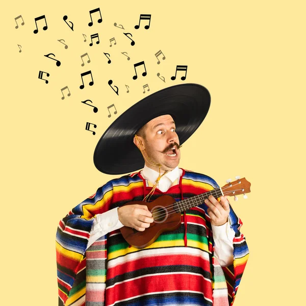 Contemporary art collage of cheerful man in mexican cloth having vinyl record sombrero playing ukulele isolated over yellow background