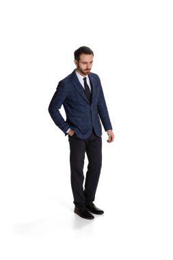 Full-length portrait of thoughtful man, businessman, office worker standing isolated over white background