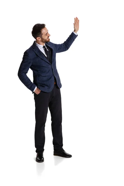 Full-length portrait of young man, office worker waving hand in excitement isolated over white background — Zdjęcie stockowe