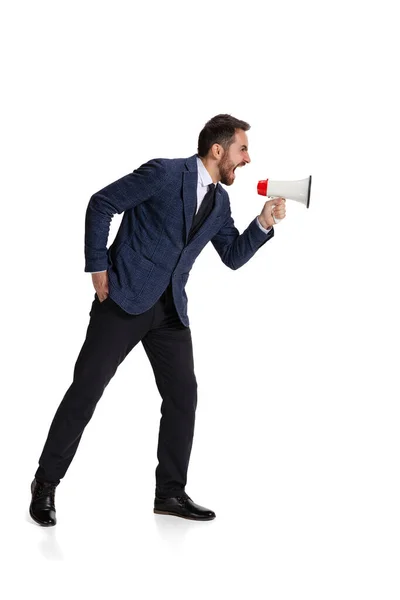 Full-length portrait of angry man, office worker shouting in megaphone isolated over white background — Fotografia de Stock