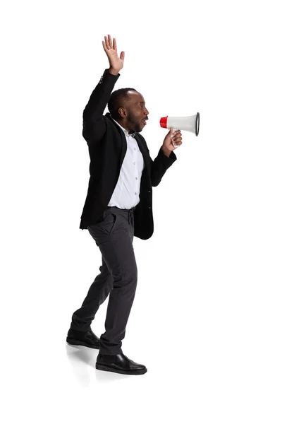Full-length portrait of young man, office worker shouting in megaphone isolated over white background — Fotografia de Stock