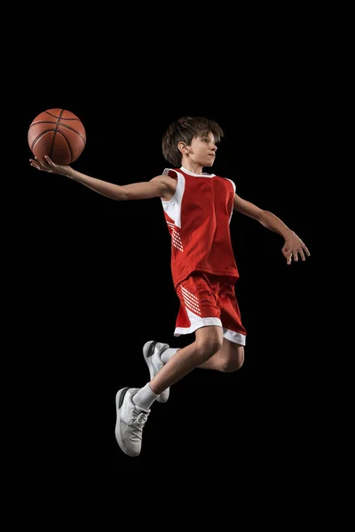 Retrato completo de adolescente, jogador de basquete em movimento, treinamento, jogando isolado sobre fundo preto — Fotografia de Stock