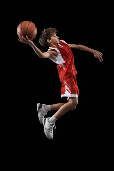 Ολο το μήκος πορτρέτο του έφηβου αγοριού, μπασκετμπολίστας σε κίνηση, προπόνηση, παιχνίδι απομονωμένο σε μαύρο φόντο. Πλευρική άποψη — Φωτογραφία Αρχείου