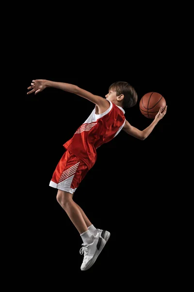 Ganztägiges Porträt eines Teenagers, Basketballspielers in Bewegung, beim Training, beim Spielen isoliert vor schwarzem Hintergrund. Seitenansicht — Stockfoto