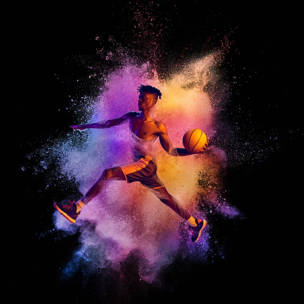 Collage. Porträtt av professionell basketspelare i att spela, utbildning isolerad över svart bakgrund med färgglada pulver explosion — Stockfoto