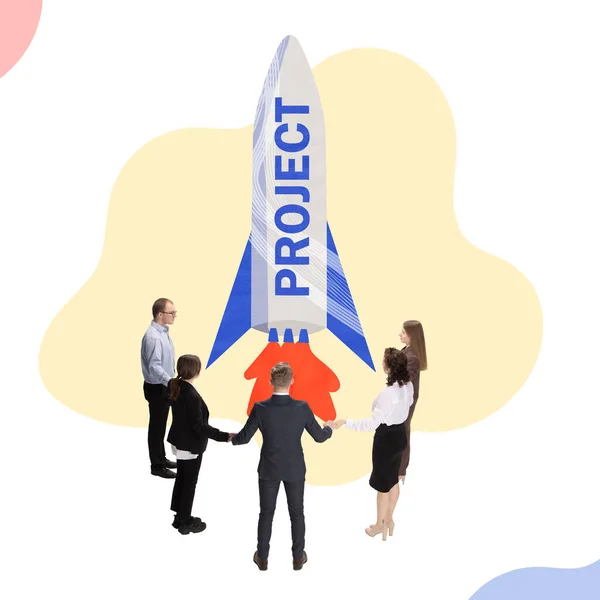 Design creativo. Gruppo di persone, dipendenti in piedi intorno a un grande razzo che simboleggia il lancio di nuovi progetti — Foto Stock