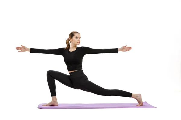 Ritratto di giovane ragazza sportiva che fa esercizi di yoga isolato su sfondo bianco studio — Foto Stock