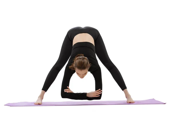 Ritratto di giovane ragazza flessibile che fa esercizi di stretching, allenamento isolato su sfondo bianco dello studio — Foto Stock