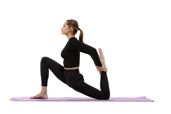 Ritratto di giovane ragazza in forma che fa pose yoga speciali per lo stretching, in piedi su mani isolate su sfondo bianco studio — Foto Stock