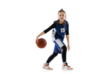 Genç bir kızın portresi, hareket halindeki basketbolcu, beyaz stüdyo arka planında izole edilmiş top sürüyor.