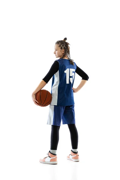 Full-length side view studio shot of young girl, basketball player in blue uniform posing isolated over white background. — Stockfoto