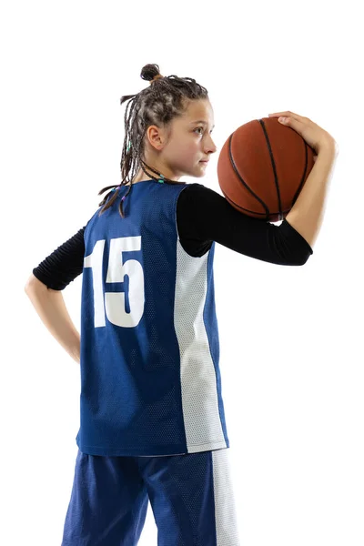Side view portrait of young girl in blue uniform, basketball player posing isolated over white studio background — Stockfoto
