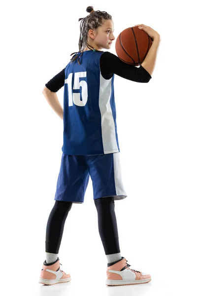 파란색 유니폼을 입고 흰색 스튜디오 배경에 고립된 채 포즈를 취하고 있는 농구 선수의 어린 소녀 사진 이 사이드에 보인다. 전체 샷 — 스톡 사진