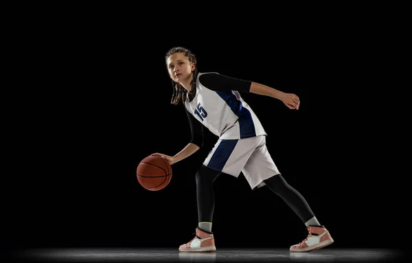 어린 소녀의 모습, 움직이는 농구 선수의 모습, 흑인 배경 위에서 격리 된 훈련. 흔들 거리는 운동. — 스톡 사진
