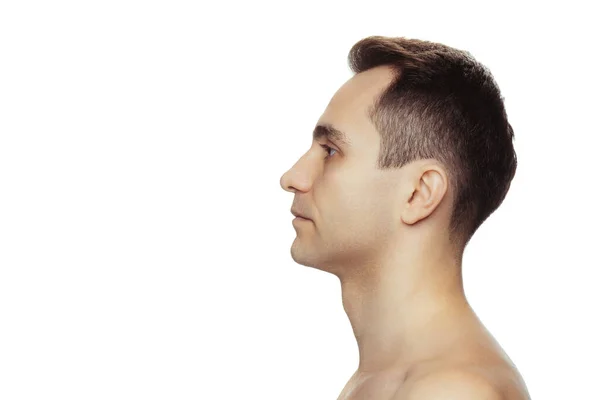 Side view portrait of young shirtless man looking away, posing isolated over white studio background —  Fotos de Stock