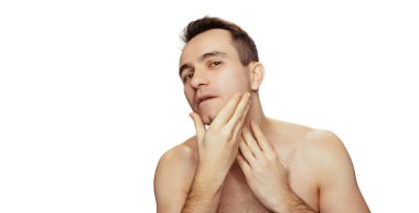 Beyaz stüdyo arka planında izole edilmiş, kusursuz tıraşlı yüzü olan çekici genç bir adamın portresi. Cilt bakımı