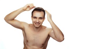 Genç üstsüz bir adamın portresi, saç fırçalama, saç stili, beyaz stüdyo arka planında izole edilmiş poz.