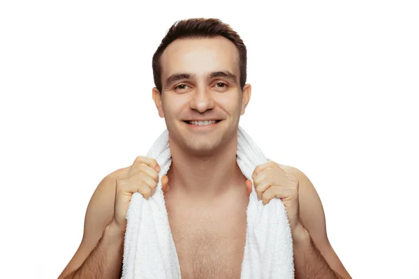 Portrait of smiling man with towel on shoulders posing isolated over white studio background. After shower — ストック写真