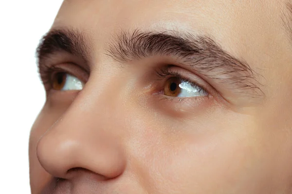 Ausgeschnittenes Porträt eines Mannes, männliche braune Augen blicken vereinzelt nach oben über weißen Studiohintergrund — Stockfoto