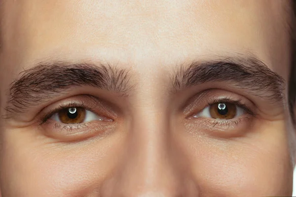 Cropped close-up portrait of beautiful male brown eyes looking at camera. Calm, attentive look. — Stockfoto