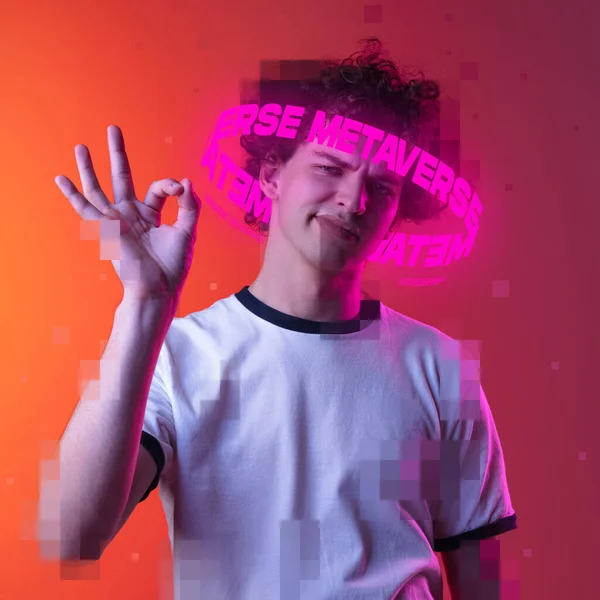 Σύγχρονα έργα τέχνης. Emotive youg άνθρωπος με νέον γράμματα γύρω από το κεφάλι pixel δείχνει OK χειρονομία απομονώνονται σε ροζ φόντο — Φωτογραφία Αρχείου