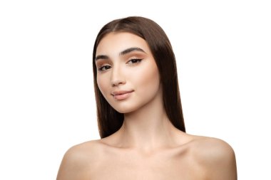 Portrait of young tender woman with straight brown hair and natural makeup look posing isolated over white studio background