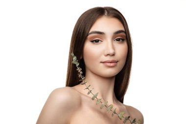 Genç ve güzel bir kadının yarım boy portresi kameraya nazikçe bakıyor, beyaz stüdyo arka planında izole edilmiş poz veriyor.