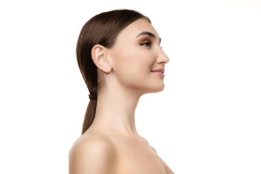 Beyaz stüdyo arka planında izole edilmiş at kuyruklu güzel bir kadının yan görünümü. Doğal görünüş