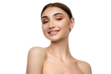 Mükemmel pürüzsüz bir teni ve beyaz arka planda izole edilmiş kameraya gülümseyen doğal makyajı olan güzel bir kadın. Kozmetoloji kavramı