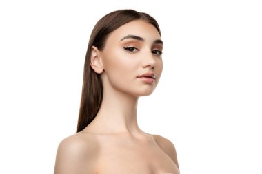 Beyaz stüdyo arka planında izole edilmiş kameraya bakarak poz veren genç bir kadının portresi. Yüz gerdirme