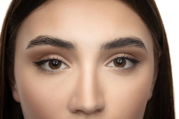 Cropped beautiful female face with nude makeup isolated over white studio background. Brown eyes beauty — Foto de Stock