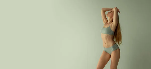 Portrait of young beautiful woman posing in underwear isolated over grey studio background. Flyer image — 스톡 사진