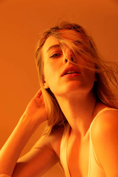 Porträt leidenschaftlicher schönes junges Mädchen posiert isoliert über orangefarbenem Studiohintergrund — Stockfoto