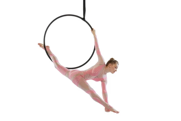 Portrait of young girl, air gymnast performing on hoop, making twine isolated over white studio background — Fotografia de Stock