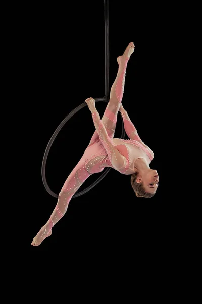 Portrait of young flexible girl, professional air gymnast performing, training isolated over black studio background. Twine position — Fotografia de Stock