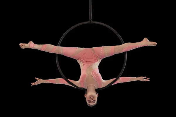 Portrait of young flexible girl, professional air gymnast performing, training isolated over black studio background. Hunging in the air — Stockfoto
