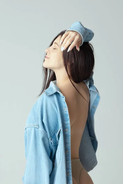 Side view. Portrait of tender woman with open back posing isolated over grey studio background. Perfect body shape — 图库照片
