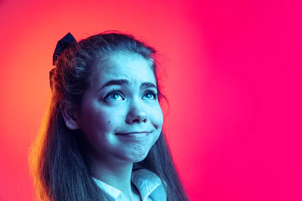 Retrato de cerca de la joven, posando de estudiante, haciendo caras divertidas aisladas sobre fondo rosa en luz de neón —  Fotos de Stock