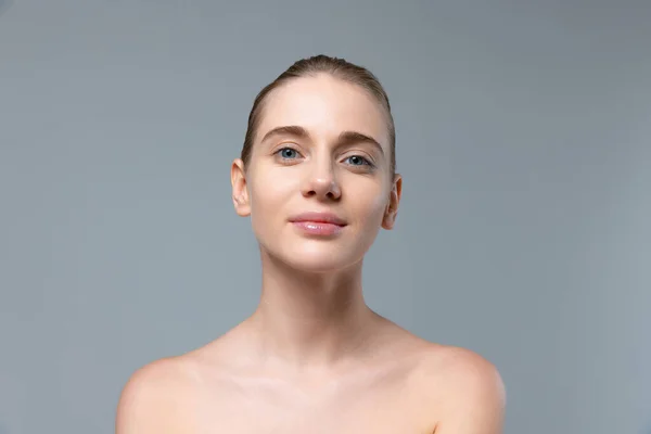 Portrait de jeune belle fille sans visage de maquillage regardant la caméra, posant isolé sur fond de studio gris — Photo