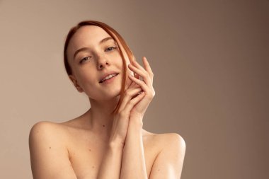 Gri stüdyo arka planında izole edilmiş güzel kızıl saçlı kızın portresi. Cilt bakımı rutini. Doğal güzellik kavramı, vücut ve cilt bakımı, sağlık, spa, sağlık, kozmetik, reklam