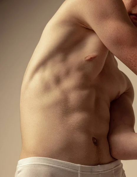 男性肌肉腹部的特写图像 模特穿着无袖上衣在灰色的背景上显得孤立无援 迷人的身体舒缓 男性美 男性健康 体格积极的概念 — 图库照片