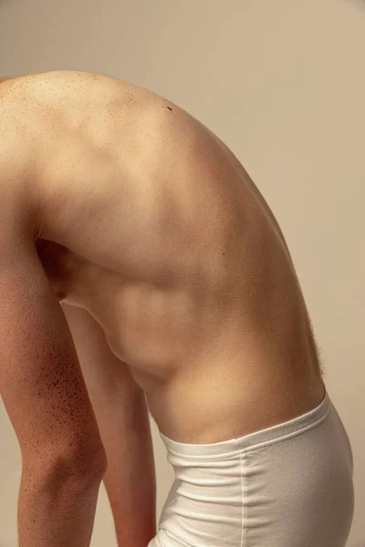 剪下的男性背像 肌肉松驰隔离在灰色工作室背景之上 模特穿着内衣裤 赤身裸体 有雀斑的尸体男性美 男性健康 健身的概念 — 图库照片