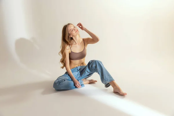 Portrait Young Slim Woman Beige Top Blue Jeans Sitting Floor — Stock Photo, Image