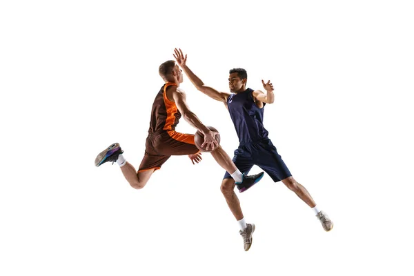 Jump shot. Dynamic portrait of two basketball playera in motion, in a jump, throwing ball into basket isolated over white studio background. Concept of sport, team game, action, active lifestyle, ad