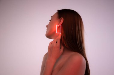 Neon renkli aksesuarları ve pembe arka planda izole edilmiş kare şeklinde küpeleri olan hassas genç bir kızın portresi. Güzellik, yaratıcılık, sanat, sayısallaştırma, moda eğilimleri kavramı