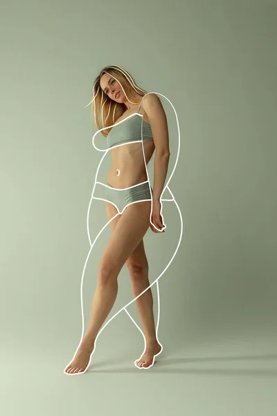 年轻而漂亮的女人穿着内衣裤 身材完美 身体周围有白线 然后在绿色的背景下减肥 健康饮食 广告的概念 — 图库照片