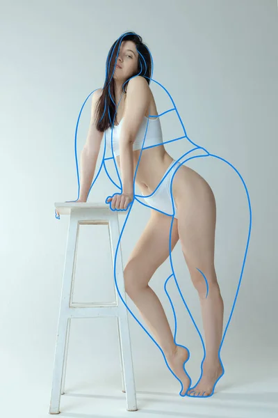 身穿内衣裤的苗条身材的女人的画像 靠在椅子上 与灰色的工作室背景隔离 减肥前身体周围的线条 健康饮食 广告的概念 — 图库照片