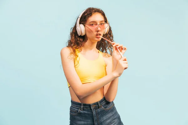 Πορτρέτο Της Νεαρής Κοπέλας Λευκά Ακουστικά Casual Ντύσιμο Τρώγοντας Καραμέλα — Φωτογραφία Αρχείου